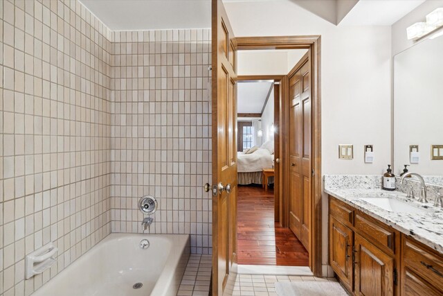 bathroom with tile patterned flooring, a tub to relax in, and vanity