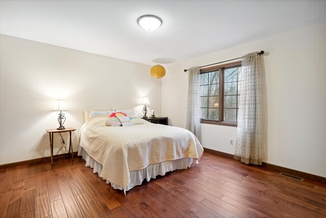 bedroom with dark wood-type flooring