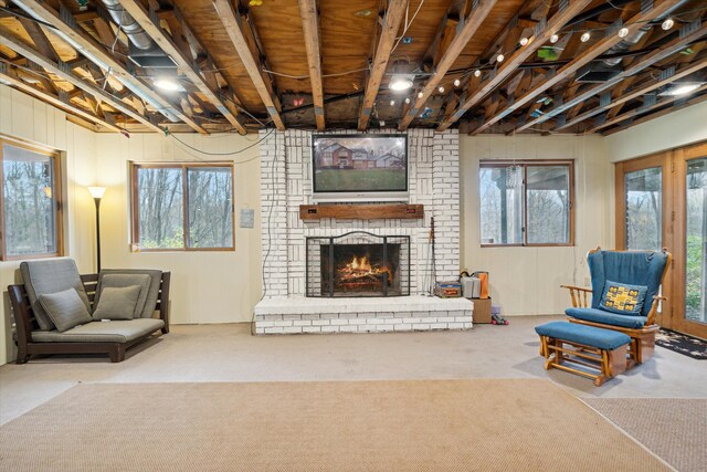 living room with a brick fireplace, carpet floors, and plenty of natural light