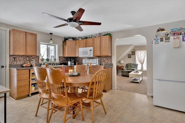 carpeted dining area with ceiling fan