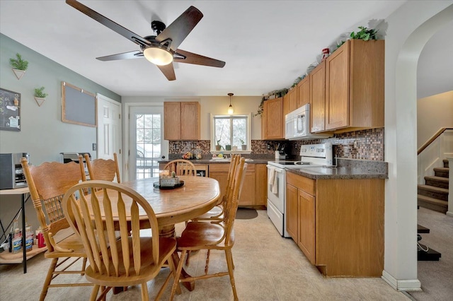 kitchen with decorative light fixtures, white appliances, ceiling fan, and tasteful backsplash