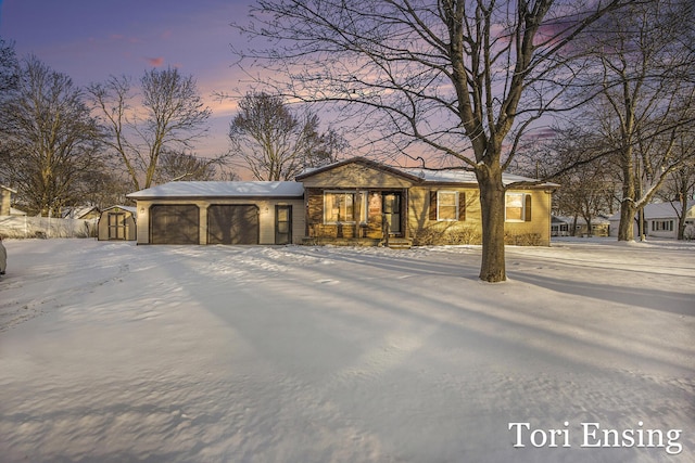 view of front of home with a garage and a storage shed