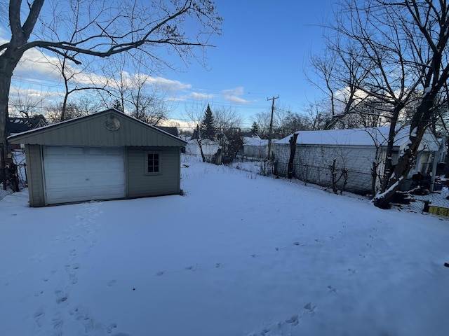 snowy yard with an outbuilding and a garage