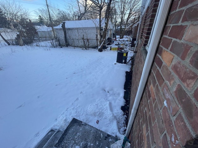 yard layered in snow featuring central AC unit