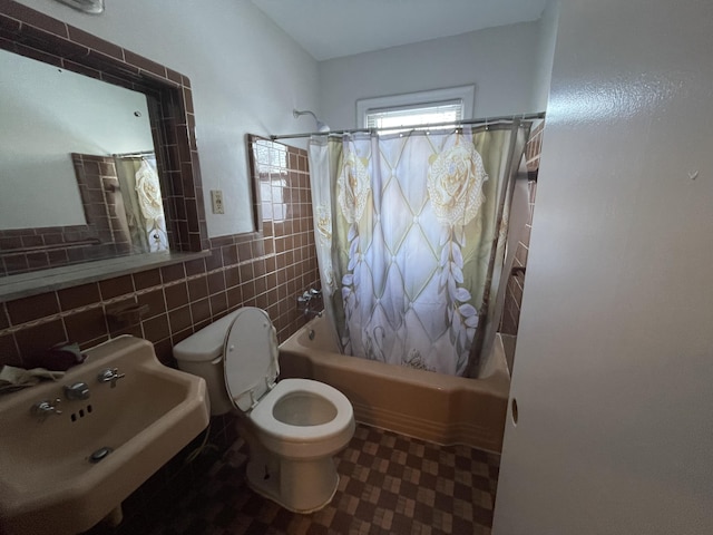 full bathroom with sink, toilet, tile walls, and shower / bath combination with curtain