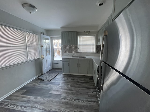 kitchen featuring sink, stainless steel fridge, gray cabinetry, and dark hardwood / wood-style floors