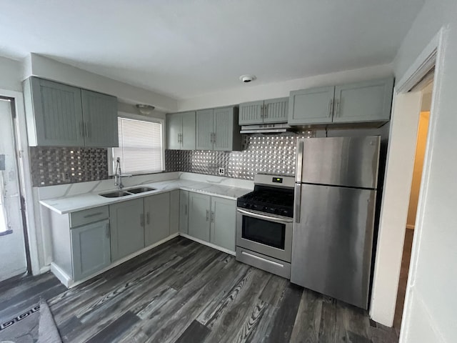 kitchen with sink, backsplash, dark hardwood / wood-style floors, gray cabinetry, and appliances with stainless steel finishes