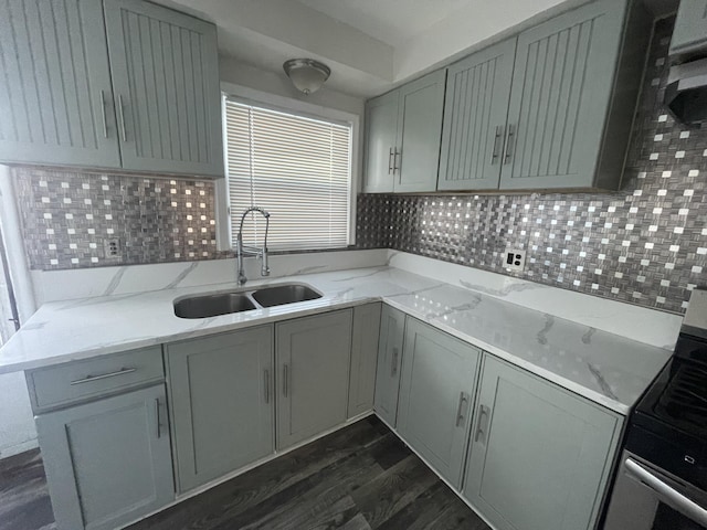 kitchen featuring sink, light stone counters, gray cabinetry, and dark wood-type flooring