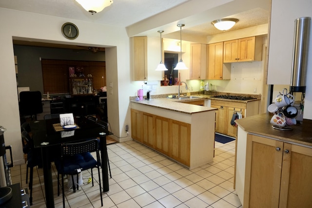 kitchen with sink, hanging light fixtures, kitchen peninsula, and light brown cabinets