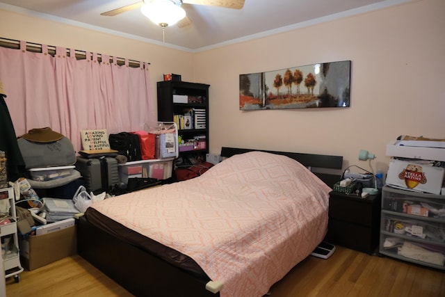 bedroom featuring ceiling fan, crown molding, and light hardwood / wood-style floors