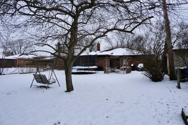 snowy yard featuring a trampoline