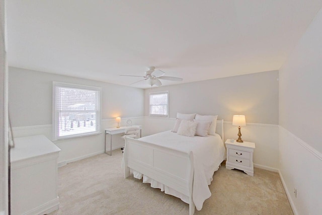 bedroom with ceiling fan, light colored carpet, and baseboards