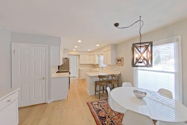 dining space featuring recessed lighting, light wood-style flooring, and plenty of natural light