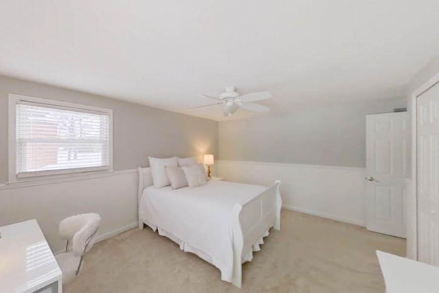 bedroom with light colored carpet and a ceiling fan