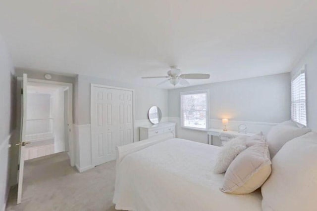 bedroom featuring ceiling fan, a closet, and light carpet