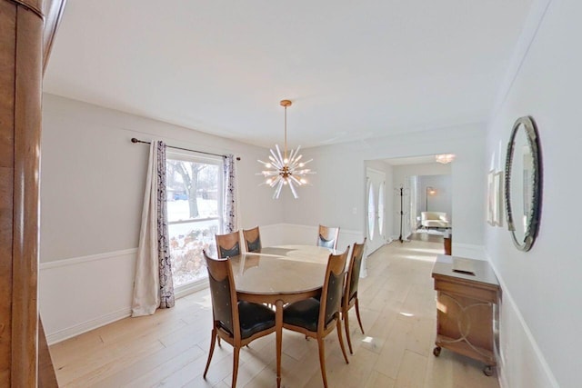 dining space featuring baseboards, light wood-style flooring, and a notable chandelier