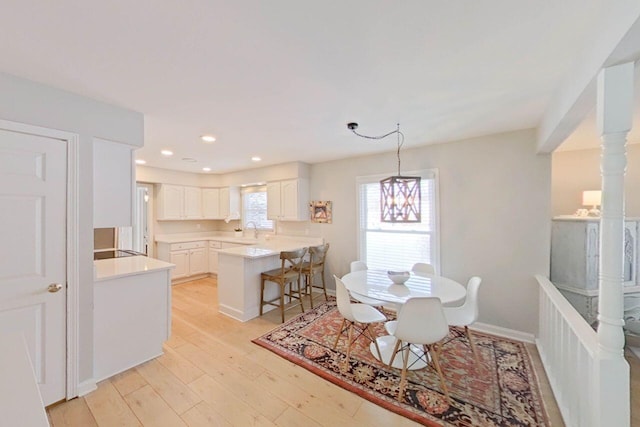 dining room with light wood finished floors, recessed lighting, and baseboards