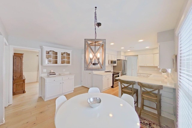 dining space with recessed lighting and light wood-type flooring