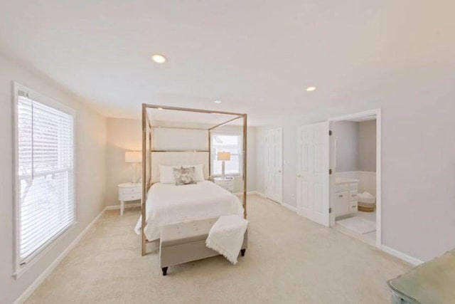 bedroom featuring baseboards, light carpet, and multiple windows
