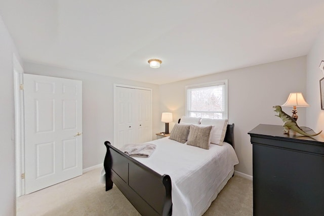 bedroom with light colored carpet, baseboards, and a closet