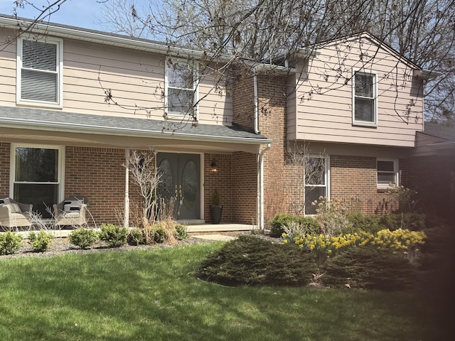traditional-style house with a front lawn and brick siding