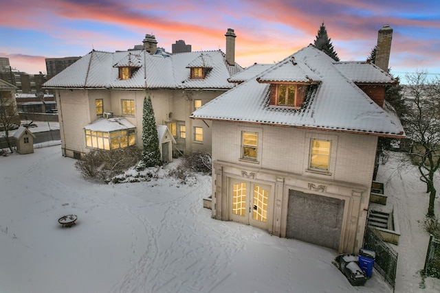 back house at dusk featuring a garage