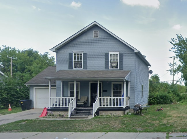 view of front facade with a front yard, a porch, and a garage