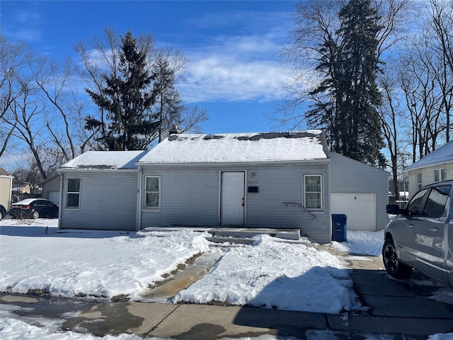 snow covered property with a garage