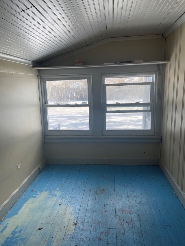 empty room with lofted ceiling, crown molding, wooden ceiling, and hardwood / wood-style floors