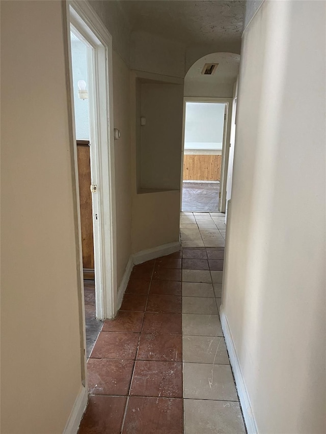 hall featuring dark tile patterned floors