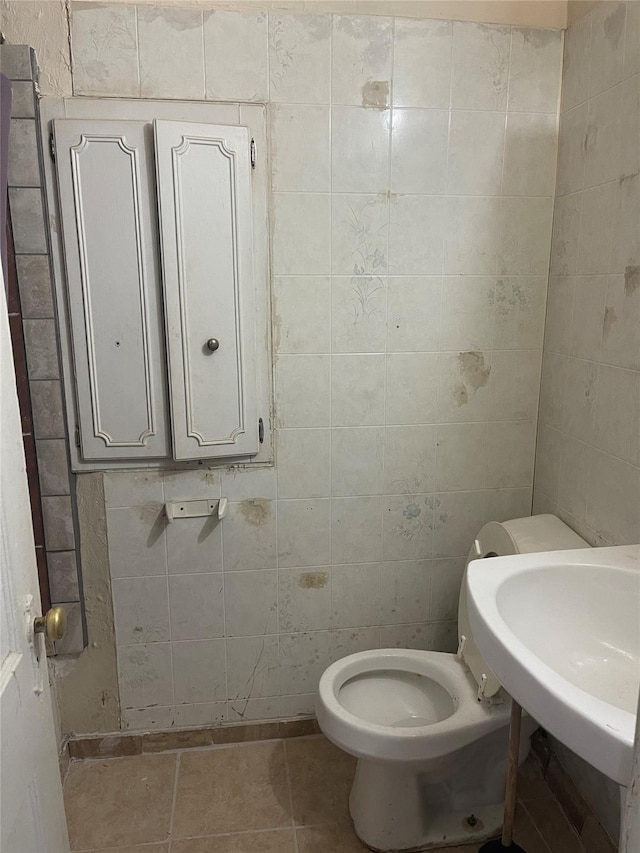 bathroom featuring toilet, tile patterned floors, and sink