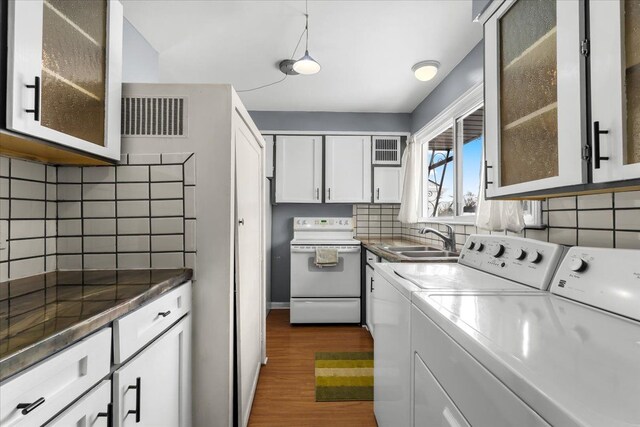 laundry area featuring dark wood-type flooring, separate washer and dryer, and sink