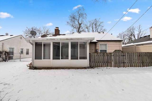 snow covered property with a sunroom