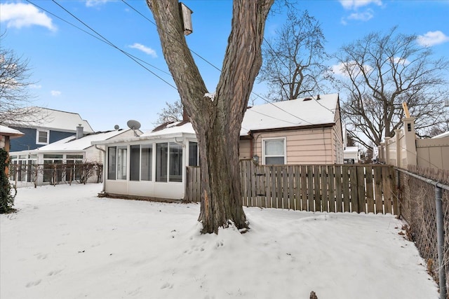 snow covered property with a sunroom