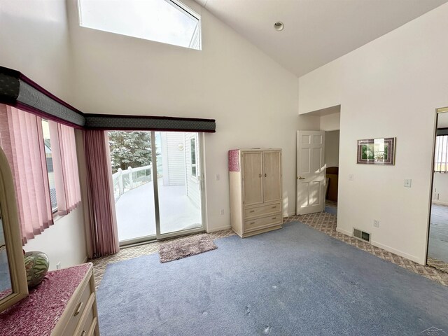 unfurnished living room featuring high vaulted ceiling, light carpet, and plenty of natural light