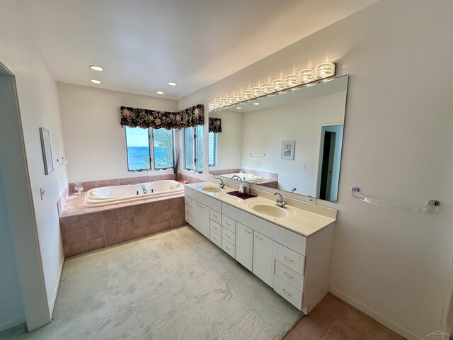 bathroom featuring tile patterned flooring, tiled tub, and vanity