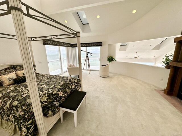 bedroom with high vaulted ceiling, carpet flooring, and a skylight