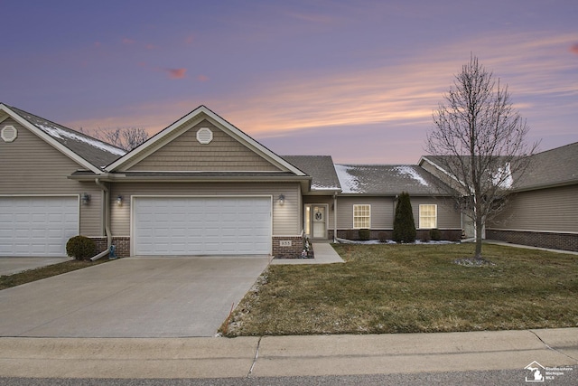 ranch-style home with a garage and a lawn