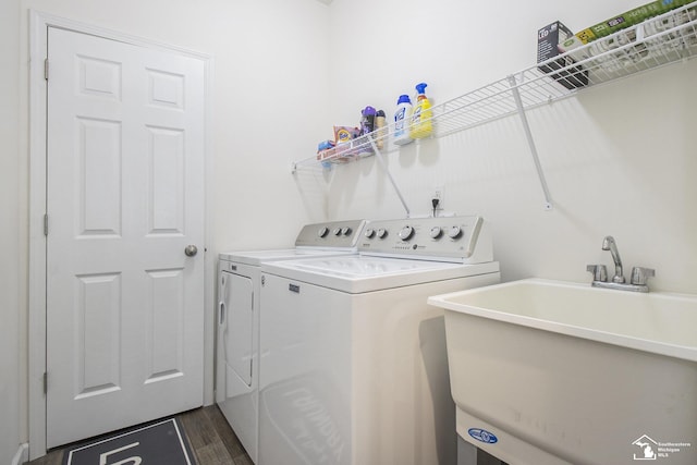 laundry room featuring washer and dryer, dark hardwood / wood-style flooring, and sink