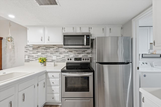 kitchen featuring backsplash, stainless steel appliances, washer and dryer, and white cabinets