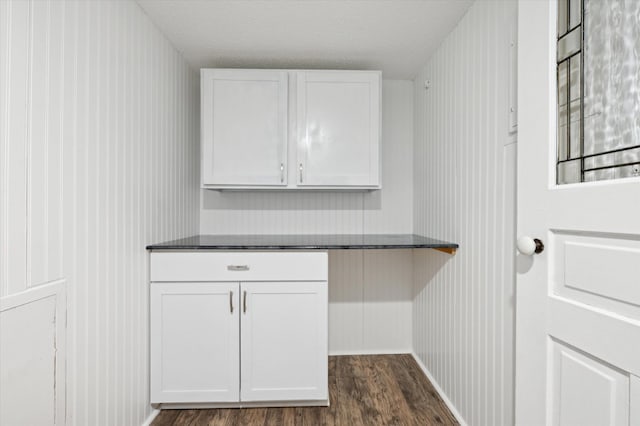 interior space with white cabinetry, dark hardwood / wood-style floors, and a textured ceiling