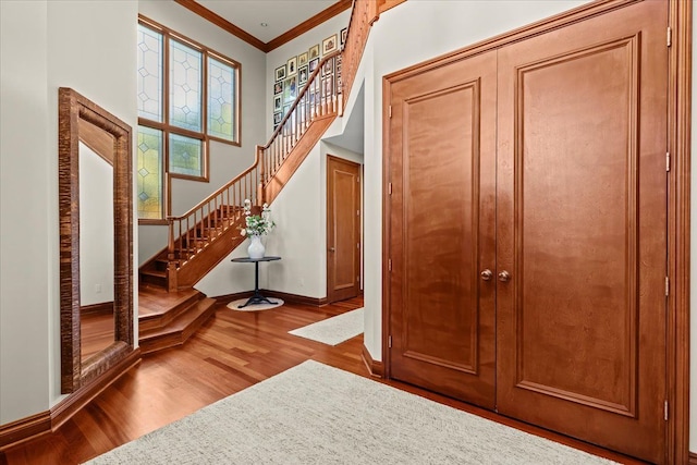 foyer entrance featuring ornamental molding and hardwood / wood-style floors