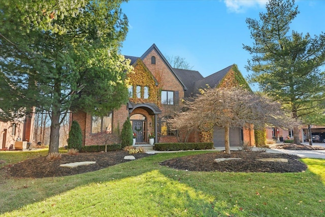 tudor house featuring a front lawn and a garage