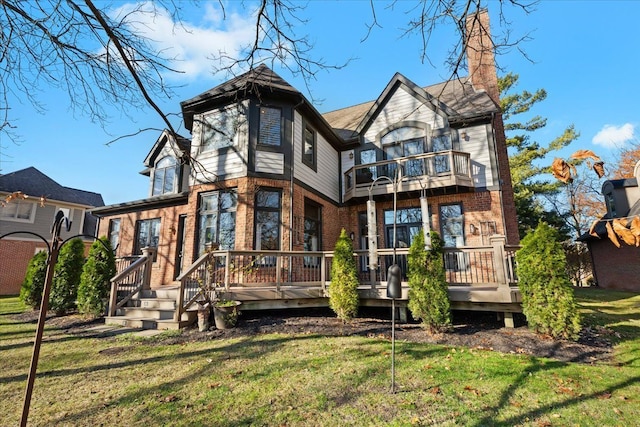 back of property with a yard, a balcony, and a wooden deck