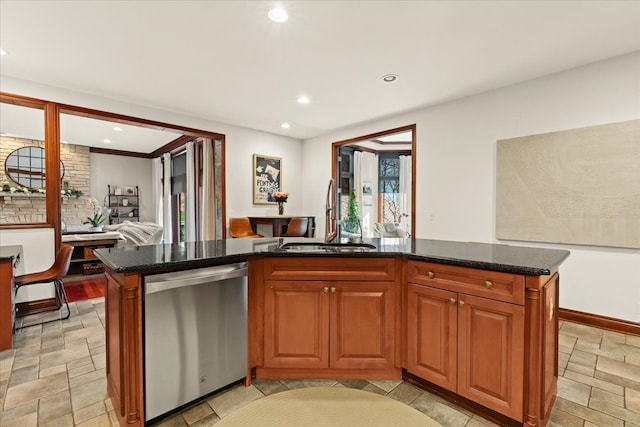 kitchen with stainless steel dishwasher, a center island, sink, and dark stone counters