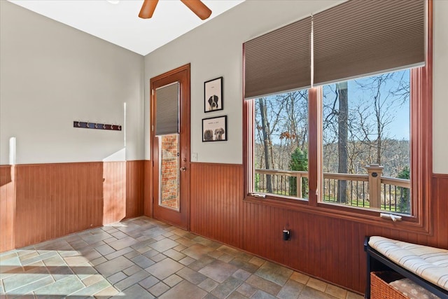 interior space featuring wood walls and ceiling fan