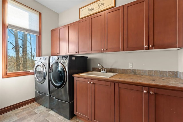 laundry room with washer and dryer, cabinets, and sink