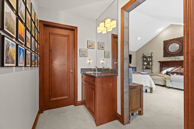 corridor with light colored carpet, vaulted ceiling, and sink