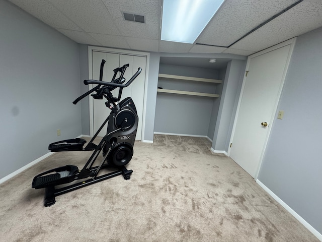 workout area featuring baseboards, carpet, visible vents, and a drop ceiling