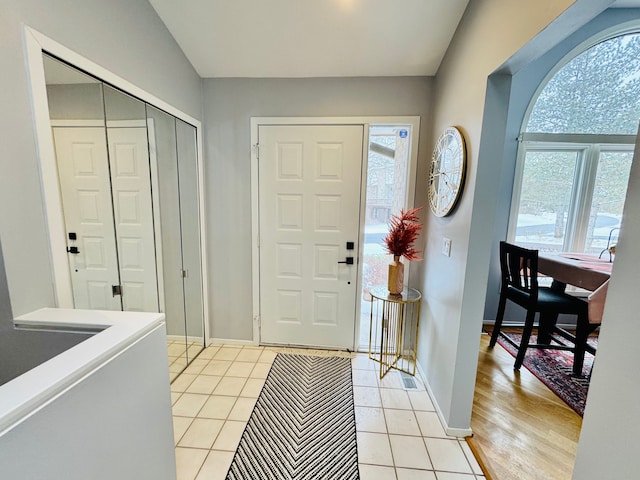 entrance foyer featuring plenty of natural light, baseboards, and light tile patterned floors